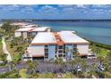 Exterior view of waterfront condos with lush tropical landscaping and convenient parking at 1701 Beach Rd # 208, Englewood, FL 34223