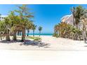 Sandy beach access with mature tropical trees, leading to calming ocean view at 180 S Gulf Blvd, Placida, FL 33946