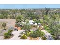 Expansive aerial view of the property showcasing mature trees, gravel driveway, and a charming brick home at 20 Spaniards Rd, Placida, FL 33946