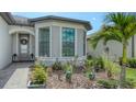 Close-up of the home's entrance and manicured landscaping with ornamental features at 2117 Laurifolia Ct, North Port, FL 34289