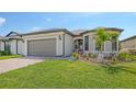 Inviting home exterior showcasing a well-maintained lawn and lovely landscaping at 2117 Laurifolia Ct, North Port, FL 34289