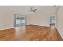 Spacious living room featuring wood flooring, a ceiling fan, and natural light at 2821 Embassy Rd, North Port, FL 34291