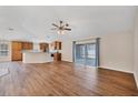 Open-concept living area with wood flooring, a ceiling fan, and sliding glass doors at 2821 Embassy Rd, North Port, FL 34291