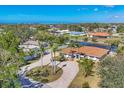 Beautiful single-story home features a circular driveway, lush landscaping, and a screened lanai at 30 Buccaneer Bnd, Placida, FL 33946