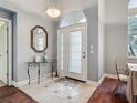 Elegant foyer features tile flooring, a decorative mirror, and a transom window above the front door at 5433 White Ibis Dr, North Port, FL 34287