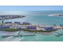 Gorgeous aerial view of beachfront condos with docks, beach, and sparkling ocean views at 6030 Boca Grande Cswy # B21, Boca Grande, FL 33921