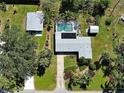 Aerial view showcasing a home with a screened pool, lush landscaping, and detached garage at 6181 Jack St, Venice, FL 34293