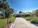 Inviting single-story home with a well-maintained lawn, concrete driveway, and colorful landscaping at 6181 Jack St, Venice, FL 34293