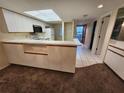 Open kitchen showcases white cabinetry, appliances, breakfast bar, and a view into the spacious adjacent living area at 6800 Placida Rd # 1004, Englewood, FL 34224
