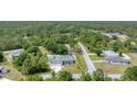 Aerial view of a well-maintained home featuring a manicured lawn, complemented by mature trees and neighboring houses at 7108 Harle Ave, North Port, FL 34291