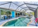 An inviting enclosed pool area with outdoor seating and kitchen at 7108 Harle Ave, North Port, FL 34291