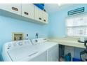 Functional laundry room with washer, dryer, cabinets, and a light blue color scheme at 7466 Palm Island Dr # 2913, Placida, FL 33946