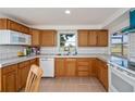 Functional kitchen featuring natural wood cabinetry, bright white countertops, and matching appliances at 81 Oakland Hills Pl, Rotonda West, FL 33947