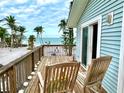 Relaxing balcony view with two wooden chairs overlooking the ocean and beach, perfect for enjoying the coastal scenery at 8714 King St, Placida, FL 33946