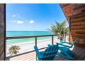Balcony view with relaxing Adirondack chairs and stunning ocean and beach views on a sunny day at 8812 Grand Ave, Placida, FL 33946