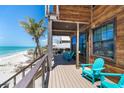 Relaxing balcony with Adirondack chairs and clear ocean views by the windows and glass doors at 8812 Grand Ave, Placida, FL 33946