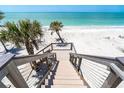 Pathway of outdoor stairs leads down to a gorgeous beach with palm trees and sparkling ocean views at 8812 Grand Ave, Placida, FL 33946