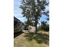 Spacious backyard featuring a large tree, an RV, a utility shed, and a chain-link fence at 941 Elwood Ave, Englewood, FL 34223