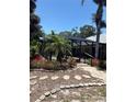 A screened-in lanai featuring gorgeous, mature landscaping at 941 Elwood Ave, Englewood, FL 34223