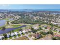 Aerial view of golf course community featuring lush greenery and sparkling blue water at 105 Westwind Dr, Placida, FL 33946