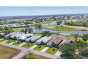 Aerial view of a serene neighborhood featuring golf course, a lake, and well-maintained homes at 105 Westwind Dr, Placida, FL 33946