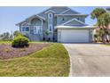 Beautiful two-story home with an attached two-car garage, landscaped yard, and inviting staircase to the front door at 10500 Sherman St, Englewood, FL 34224