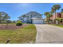 Two-story home featuring lush landscaping, palm trees, and a driveway leading to an attached two-car garage at 10500 Sherman St, Englewood, FL 34224