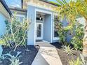 Beautiful front entrance with lush landscaping and a welcoming doorway with glass features at 1167 Rotonda Cir, Rotonda West, FL 33947