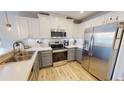 Bright kitchen with white cabinets, stainless steel appliances, and wood flooring at 11750 Tempest Harbor Loop, Venice, FL 34292