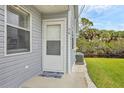 Inviting entryway featuring a welcoming door, adjacent window, and manicured landscaping at 14454 Worthwhile Rd, Port Charlotte, FL 33953