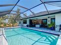 Inviting screened-in pool with lounge chairs and views of the home's open living area at 16 Pine Valley Ct, Rotonda West, FL 33947