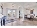 Spacious entryway that leads into a dining room with an elegant chandelier, and view to the outdoor balcony at 1953 Georgia Ave, Englewood, FL 34224