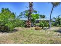 A one-story home with mature trees and natural landscaping in the front yard at 2128 Pennsylvania Ave, Englewood, FL 34224