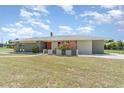 Single-story home with a manicured front lawn, bright entrance, and modern color palette at 2140 Carnac St, Port Charlotte, FL 33952