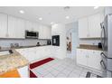 Bright kitchen featuring granite countertops, white cabinetry, stainless steel appliances, and an adjoining breakfast nook at 23347 Lehigh Ave, Port Charlotte, FL 33954