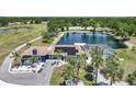 Aerial view of a blue home with a pool, screened enclosure, solar panels, and scenic pond at 24805 Nova Ln, Punta Gorda, FL 33980