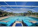 Enclosed pool area with lounge chairs, dining set, and scenic lake views at 24805 Nova Ln, Punta Gorda, FL 33980