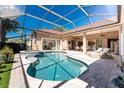 Screened-in pool and spa with patio lounge chairs at 26 Saint Croix Way, Englewood, FL 34223