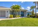 Close up of a beautifully landscaped home with a well-maintained lawn and attractive shrubbery surrounding the entrance at 27 Sportsman Cir, Rotonda West, FL 33947