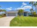 Well-maintained home featuring lush green lawn, elegant landscaping, and a spacious driveway leading to an attached garage at 27 Sportsman Cir, Rotonda West, FL 33947