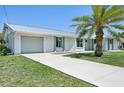 Well-maintained single-Gathering home featuring a metal roof and a lush, green front yard with a swaying palm tree at 3246 Yukon Dr, Port Charlotte, FL 33948
