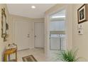 Welcoming foyer with neutral tile flooring and adjacent laundry room with washer, dryer, and overhead cabinets at 3433 Grand Vista Ct # 102, Port Charlotte, FL 33953