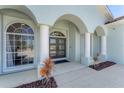 Inviting front porch with elegant columns, arched entryways, and decorative landscaping for a warm welcome at 39 Fairway Rd, Rotonda West, FL 33947