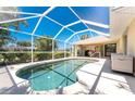 The caged-in pool is a perfect oasis and the yard is surrounded by privacy hedges to provide seclusion at 4 Pine Valley Ln, Rotonda West, FL 33947
