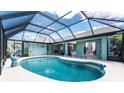 Screened-in pool area offers privacy and relaxation with ample seating and lush greenery, perfect for entertaining at 417 Rotonda Cir, Rotonda West, FL 33947