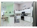 Bright kitchen featuring white cabinets, modern appliances, decorative backsplash, and an adjacent eat-in dining area at 4207 Fairway Pl, North Port, FL 34287