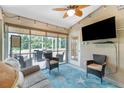 Cozy screened porch with comfortable seating, a ceiling fan, TV and an outdoor view at 4207 Fairway Pl, North Port, FL 34287