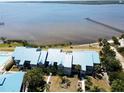 Beautiful aerial view of condos, surrounding landscape, and scenic waterfront with a long pier at 4410 Warren Ave # 104, Port Charlotte, FL 33953