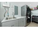 Well-organized laundry room features modern washer and dryer, utility sink and plentiful storage at 5030 N Beach Rd # 1, Englewood, FL 34223