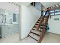 Interior staircase next to laundry area including modern sink, cabinets, and gray washing machine at 5030 N Beach Rd # 1, Englewood, FL 34223